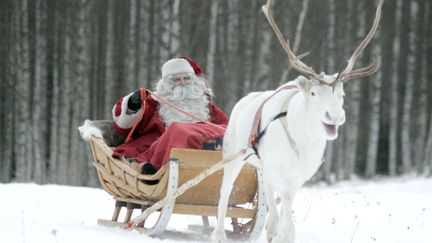 Un homme d&eacute;guis&eacute; en p&egrave;re No&euml;l sur son tra&icirc;neau dans le nord de la Finlande, le 19 d&eacute;cembre 2007. (KACPER PEMPEL / REUTERS)