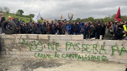 Les manifestants venus protester contre le projet d'autoroute reliant Castres à Toulouse ont érigé un petit mur au milieu de la route à coups de parpaings, le 22 avril 2023 à Soual (Tarn). (THOMAS BAIETTO / FRANCEINFO)