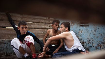 Des Syriens se réfugient à l’arrière d’un camion, après avoir été blessés par des tirs de mortiers. (AFP PHOTO / FABIO BUCCIARELLI)