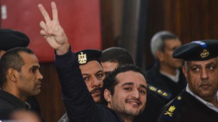 Ahmed Douma, éminent militant de l'opposition égyptienne, brandit le signe V de la victoire devant le tribunal, lors de son procès le 4 février 2015 au Caire. Jugé aux côtés de 230 militants de la révolte de 2011 contre Hosni Moubarak, tous ont été condamnés à la prison à vie. (MOHAMED EL-RAAY / AFP)