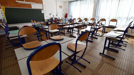 Des chaises sur des tables dans une salle de classe vide. (ALEXANDRE MARCHI / MAXPPP)