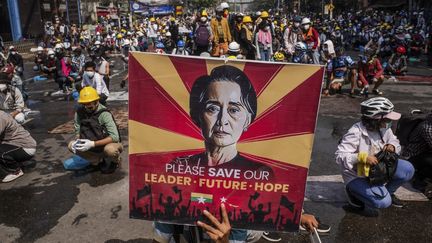 Des manifestants brandissent un portrait de l'ancienne dirigeante birmane, Aung San Suu Kyi, à Yangon, le 2 mars 2021.&nbsp;&nbsp; (AFP)