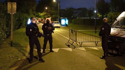 Des policiers gardent l'accès à la rue dans laquelle l'assaillant qui a décapité un professeur a été abattu par les forces de l'ordre, à Eragny (Val-d'Oise), le 16 octobre 2020. (ABDULMONAM EASSA / AFP)