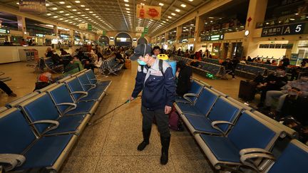 Un employé désinfecte le hall d'attente de la gare de Wuhan (Chine), le 22 janvier 2020. A l'époque, la ville n'est pas encore confinée. (STR / AFP)