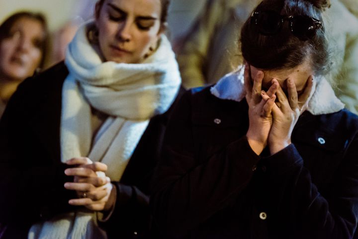 Des badauds prient devant l'incendie qui a ravagé Notre-Dame de Paris, le 15 avril 2019.&nbsp; (SIMON GUILLEMIN / HANS LUCAS / AFP)