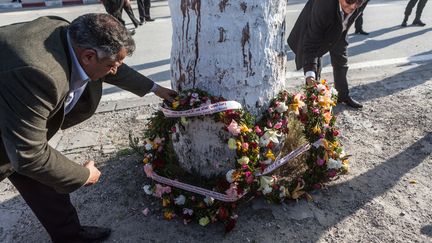 Un homme d&eacute;pose des fleurs le 19 mars 2015 pr&egrave;s du mus&eacute;e du Bardo &agrave; Tunis (Tunisie), o&ugrave; a eu lieu une attaque terroriste, la veille. (AMINE LANDOULSI / ANADOLU AGENCY / AFP)