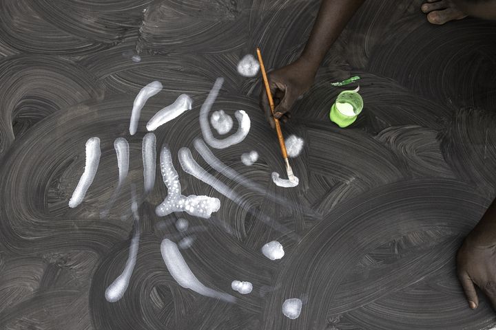 Le peintre Omar Ba au travail dans son atelier de&nbsp;Sangalkam (9 mai 2022) (JOHN WESSELS / AFP)