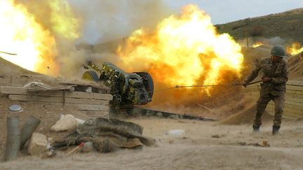 Un&nbsp;soldat de l'armée de défense du Karabakh tire avec une pièce d'artillerie en direction des positions azerbaïdjanaises, le 4 octobre 2020. (RAZMINFO / ARMENIAN DEFENCE MINISTRY / AFP)