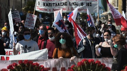 A Thessalonique, deuxième ville de Grèce,&nbsp;ce défilé de&nbsp;membres du syndicat PAME le 1er mai 2020 a ressemblé&nbsp;aux manifestations habituelles, à l'exception des masques qui couvraient les visages. Mais, plus tôt, ces manifestants s'étaient rassemblées sur une place en respectant une distance de sécurité. (SAKIS MITROLIDIS / AFP)