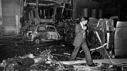 Un inspecteur de police sur les lieux de l'attentat de la rue Copernic à Paris, survenu le 3 octobre 1980. (GEORGES GOBET / AFP)