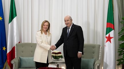 La Première ministre italienne Giorgia Meloni et le président algérien Abdelmadjid Tebboune se serrent la main lors de leur rencontre au palais présidentiel d'Alger, le 23 janvier 2023. (HANDOUT / PALAZZO CHIGI PRESS OFFICE)