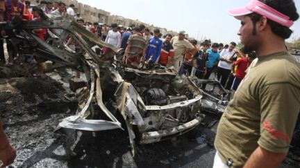 Les restes d'une voiture piégée après un attentat dans le quartier de Sadr City à Bagdad (AFP - AHMAD AL-RUBAYE)