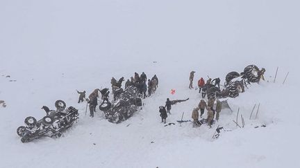 Des membres des services d'urgence creusent dans la neige autour d'au moins trois véhicules renversés, près de la ville de Bahcesehir, dans la province de Van, à l'est de la Turquie, le 5 février 2020.&nbsp; (DHA / AFP)