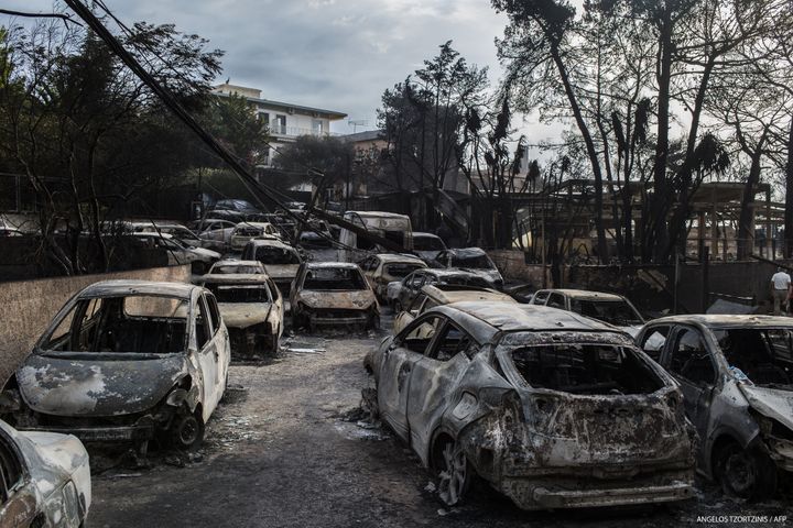 Des voitures brulées à Mati, en Grèce, après un incendie, le 24 juillet 2018.&nbsp; (ANGELOS TZORTZINIS / AFP)