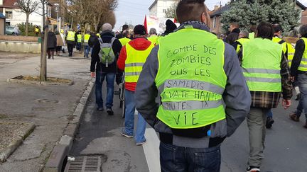 Environ 500 personnes ont défilé à Besançon (Doubs) le 9 février 2019 pour l'acte XIII des gilets jaunes. Sur le dos d'un manifestant : "Comme des zombies tous les samedis on va te hanter toute ta vie". (MARIE-CORALIE FOURNIER / FRANCE-BLEU BESANÇON)