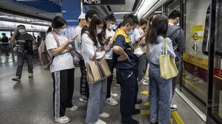 Des Chinois attendent le métro à Guangzhou en Chine, le 15 novembre 2022. (STRINGER / ANADOLU AGENCY / AFP)