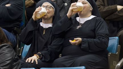 Deux femmes habill&eacute;es en religieuses boivent de la bi&egrave;re en attendant le d&eacute;but du match opposant le Qu&eacute;bec &agrave; Manitoba lors du&nbsp;Brier Tim Hortons, le championnat de curling masculin canadien &agrave; Kamloops (Canada), le 8 mars 2014. (BEN NELMS / REUTERS)