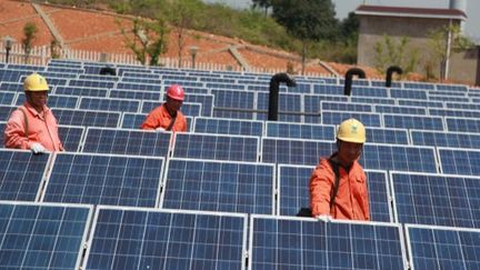 Des techniciens inspectent des panneaux solaires &agrave; Ningguo, dans la province d'Anhui (est de la Chine). (SONG WEIXING / IMAGINECHINA / AFP)