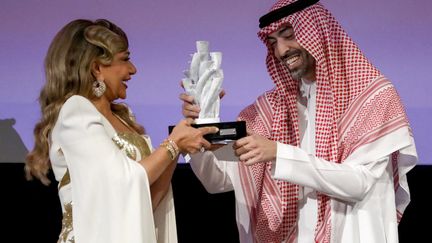 L'actrice égyptienne Laila Eloui reçoit une récompense pour l'ensemble de sa carrière des mains du maître de cérémonie,&nbsp;Mohamed al Turki, lors de la première édition du film de Jeddah.&nbsp; (PATRICK BAZ / RED SEA FILM FESTIVAL)