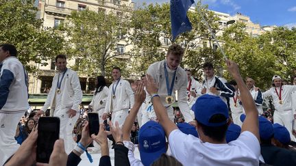 Léon Marchand, quadruple médaillé d'or aux Jeux de Paris en natation, communie avec les partenaires de Paris 2024, devant une foule très nombreuse, le 14 septembre 2024, sur les Champs-Elysées pour la parade des champions. (CLEMENT MARIOTTI PONS / FRANCEINFO: SPORT)