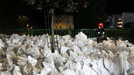 Les pompiers tentent de limiter les dégâts causés par les inondations qui touchent la ville de Glucholazy (Pologne), en distribuant des sacs de sable, le 14 septembre 2024. (SERGEI GAPON / AFP)