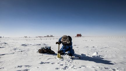 Un chercheur creuse la glace afin de recuperer des échantillons de glace&nbsp;près de la station Concordia, le 8 février 2013. (FRANCOIS LEPAGE / HANS LUCAS)