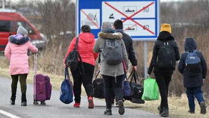 Des réfugiés ukrainiens traversent la frontière avec la Hongrie, le 28 février 2022, à Barabas.&nbsp; (ATTILA KISBENEDEK / AFP)