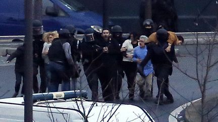 Des membres des forces de l'ordre &eacute;vacuent des otages apr&egrave;s l'assaut sur un magasin casher de Paris o&ugrave; Amedy Coulibaly retenait une quinzaine de personnes, le 9 janvier 2015. (THOMAS SAMSON / AFP)