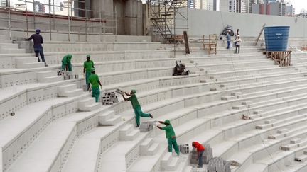  (© Maxppp - Des hommes au travail sur le chantier du stade Arena da Baixada, à Curitiba, ville-hôte du Mondial.)