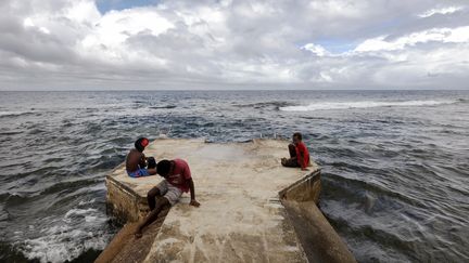 Des habitants du Vanuatu assis sur la jetée d'un port à Tanna, le 6 décembre 2019. (MARIO TAMA / GETTY IMAGES ASIAPAC)