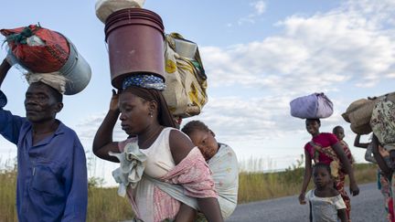 Des familles déplacées fuient le 14 juin 2022 des insurgés armés qui ont attaqué leur communauté dans la province de Cabo Delgado, au Mozambique.  (ALFREDO ZUNIGA / AFP)