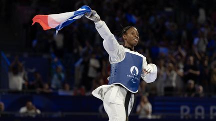 Le drapeau tricolore au vent, la taekwondoïste française Djelika Diallo a couronné une belle soirée pour la délégation française, vendredi 30 août. Après une journée exceptionnelle au Grand Palais, la jeune athlète de 19 ans s'est inclinée en finale face à la Brésilienne Ana Carolina Silva de Moura, remportant ainsi une médaille d'argent, la première pour la France dans la discipline. (LOYSEAU BENJAMIN / AFP)