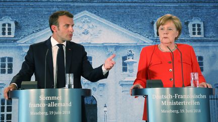 Emmanuel Macron et Angela Merkel lors d'une conférence de presse commune à&nbsp;Meseberg, en Allemagne, le 19 juin 2018.&nbsp; (LUDOVIC MARIN / AFP)