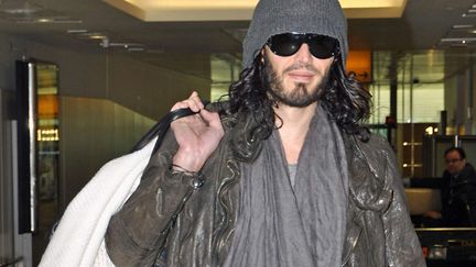 Sans Katy Perry, Russell Brand est tout perdu. Au point qu'il se balade avec sa couverture doudou pour prendre l'avion. Si c'est pas gnongnon... (REX / SIPA)