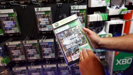 Une personne tient un exemplaire du jeu GTA V, le 17 septembre 2013, dans une boutique &agrave; Paris. (MAXPPP)