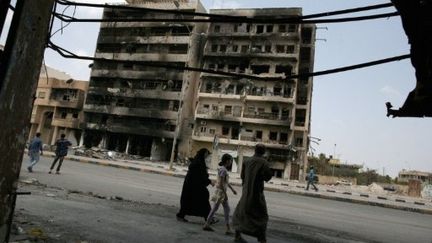 Des habitants passent devant des bâtiments détruits dans la ville Misrata, le 12 mai 2011. (AFP - Wissam Saleh)