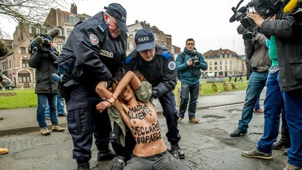 Une militante des Femen arr&ecirc;t&eacute;e par la police, &agrave; proximit&eacute; du tribunal correctionnel de Lille (Nord), le 10 f&eacute;vrier 2015, au moment de l'arriv&eacute;e de Dominique Strauss-Kahn. (PHILIPPE HUGUEN / AFP)