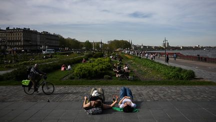 Des personnes se reposent au soleil, le 5 avril 2024 à Bordeaux (Gironde). (PHILIPPE LOPEZ / AFP)