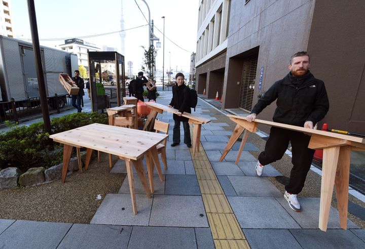 Les artistes menuisiers Sébastien Renauld et Laurent Boijeot ici à Tokyo en novembre 2015 avec les meubles construits sur place.
 (TOSHIFUMI KITAMURA / AFP)