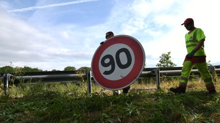 Des employés de la DIR est remplacent des panneaux de vitesse sur une route départementale (illustration). (SEBASTIEN BOZON / AFP)