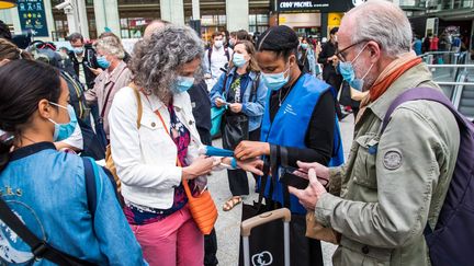 Le pass sanitaire de passagers contrôlé par des agents de la SNCF avant l'embarquement gare de Lyon à Paris, le 9 août 2021. (CHRISTOPHE PETIT TESSON / EPA)