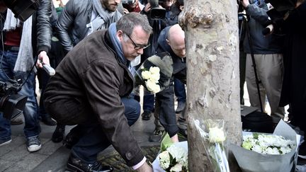 Denis Jacob, secrétaire général du syndicat Alternative police, dépose une gerbe de fleurs sur les Champs-Elysées, à Paris, le 21 avril 2017. (PHILIPPE LOPEZ / AFP)