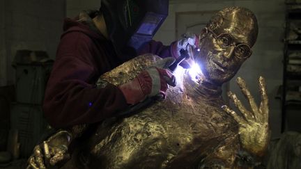 Un assistant du sculpteur hongrois Emo Toth effectue les derni&egrave;res retouches sur le bronze de Steve Jobs, le co-fondateur d'Apple &agrave; Budapest (Hongrie), le 6 d&eacute;cembre 2011. (LAZSLO BALOGH / REUTERS)