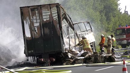 Les pompiers éteignent l'incendie du car accidenté, lundi 3 juillet 2017, près de Münchberg, en Allemagne.&nbsp; (REUTERS)