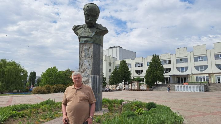 L'ancien maire de Borodyanka, Heorgi Erko, devant le buste de l'écrivain ukrainien Taras Chevtchenko, abîmé par les tirs, le 10 juin 2024. (VIRGINIE PIRONON / RADIO FRANCE)