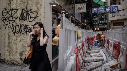 Une passante se bouche les oreilles pour se protéger du bruit de travaux à Hong Kong, le 9 juillet 2013. (PHILIPPE LOPEZ / AFP)