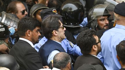 Des policiers escortent l'ancien Premier ministre pakistanais Imran Khan à son arrivée à la Haute Cour d'Islamabad, le 12 mai 2023. (AAMIR QURESHI / AFP)