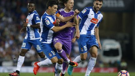 Luka Modric s'infiltre entre deux joueurs de l'Espanol Barcelone (PAU BARRENA / AFP)