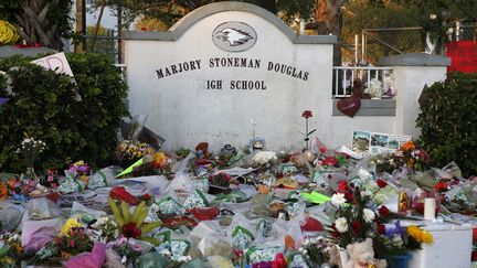 Des fleurs et bougies déposées devant le lycée Marjory Stoneman Douglas à Parkland, en Floride (Etats-Unis), le 27 février 2018.&nbsp; (RHONA WISE / AFP)