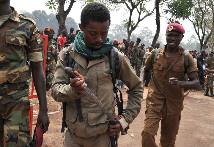 Un membre des forces arm&eacute;es centrafricaines (FACA) range son arme apr&egrave;s le lynchage d'un homme soup&ccedil;onn&eacute; d'entre un ancien rebelle de la Seleka, le 5 f&eacute;vrier 2014 &agrave; Bangui (Centrafrique). (ISSOUF SANOGO / AFP)